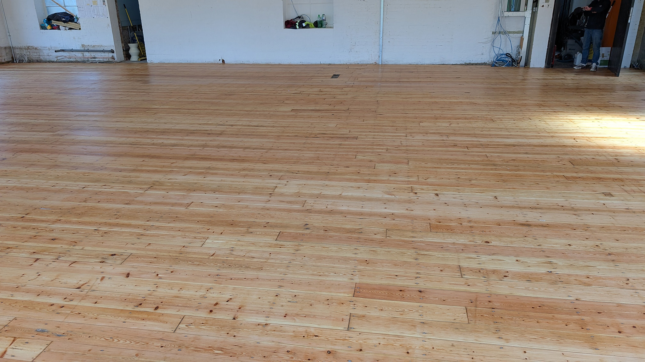 Restored pine floorboards in a large open commercial space